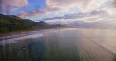 Animation of landscape with ocean over family embracing at beach. ocean day and celebration concept digitally generated video.