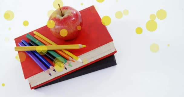 Animation Gelber Flecken Über Äpfeln Und Buntstiften Auf Bücherstapeln Internationaler — Stockvideo