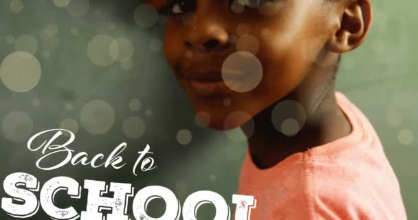 幸せなアフリカ系アメリカ人の少年についての学校のテキストに戻るアニメーション 世界中の教育と学校のコンセプトをデジタルで — ストック動画