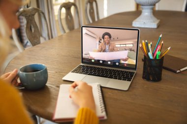 Afrika kökenli Amerikalı iş adamı laptopta iş arkadaşlarıyla raporu tartışıyor. değiştirilmemiş, çevrimiçi, kablosuz teknoloji, video konferansı, tartışma, internet, iş dünyası, takım çalışması.