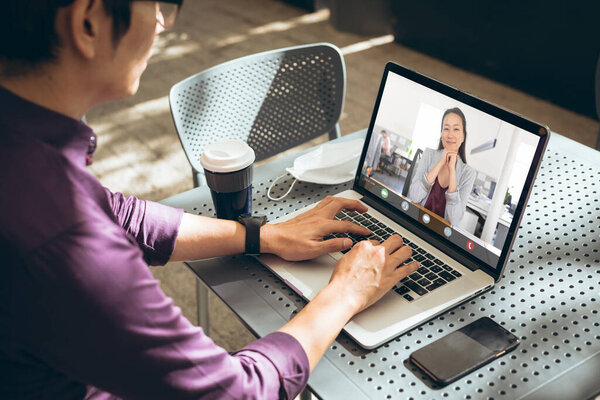 Asian businessman and businesswoman working online through laptop in office. unaltered, covid, online, wireless technology, discussion, internet, business, teamwork.