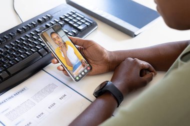 Afrika kökenli Amerikalı iş kadını ve iş adamı ofiste video görüşmeleri yaparken raporu tartışıyorlar. değiştirilmemiş, çevrimiçi, kablosuz teknoloji, video konferansı, tartışma, internet, iş dünyası, takım çalışması.