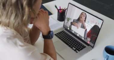 Kafkasyalı iş kadını, iş arkadaşlarıyla görüntülü konuşma yapmak için laptop kullanıyor. ticari iletişim teknolojisi, dijital kompozit video.