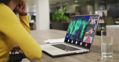 Çift ırklı iş kadını çeşitli iş arkadaşlarıyla görüntülü konuşma için dizüstü bilgisayar kullanıyor. ticari iletişim teknolojisi, dijital kompozit video.