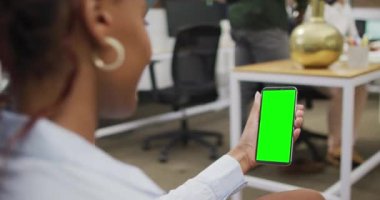 Afro-Amerikalı iş kadını akıllı telefonu fotokopi alanı ile video görüşmesi için kullanıyor. ticari iletişim teknolojisi, dijital kompozit video.