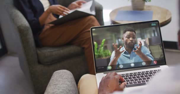 アフリカ系アメリカ人のビジネスマンがアフリカ系アメリカ人のビジネスの同僚とビデオ通話のためにラップトップを使用する ビジネスコミュニケーション技術デジタル複合ビデオ — ストック動画