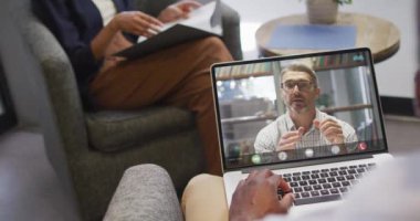 Afrikalı Amerikalı iş adamı, beyaz iş arkadaşlarıyla görüntülü görüşme için laptop kullanıyor. ticari iletişim teknolojisi, dijital kompozit video.
