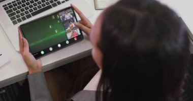 Çeşitli iş arkadaşlarıyla video görüşmesi için tablet kullanan iki ırklı bir iş kadını. ticari iletişim teknolojisi, dijital kompozit video.
