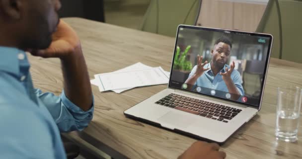 アフリカ系アメリカ人のビジネスマンがアフリカ系アメリカ人のビジネスの同僚とビデオ通話のためにラップトップを使用する ビジネスコミュニケーション技術デジタル複合ビデオ — ストック動画