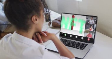 Çift ırklı bir kadının iş arkadaşlarıyla görüntülü konuşma yaptığı bir video. iş, işbirliği, dijital kaynaklar ve dijital olarak üretilen teknoloji konseptiyle ofiste çalışmak.