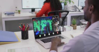 Afro-Amerikan bir adamın laptopta çeşitli iş arkadaşlarıyla görüntülü konuşma yaptığı bir video. iş, işbirliği, dijital kaynaklar ve dijital olarak üretilen teknoloji konseptiyle ofiste çalışmak.