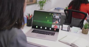 Kafkasyalı bir kadının çeşitli iş arkadaşlarıyla dizüstü bilgisayarda görüntülü konuşma yaptığı video. iş, işbirliği, dijital kaynaklar ve dijital olarak üretilen teknoloji konseptiyle ofiste çalışmak.