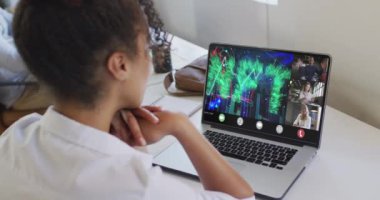 Çift ırklı bir kadının laptopta çeşitli iş arkadaşlarıyla görüntülü konuşma yaptığı bir video. iş, işbirliği, dijital kaynaklar ve dijital olarak üretilen teknoloji konseptiyle ofiste çalışmak.