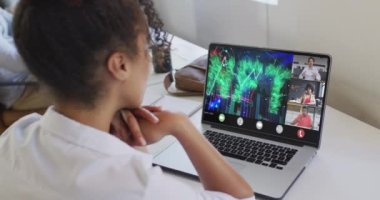Çift ırklı bir kadının iş arkadaşlarıyla görüntülü konuşma yaptığı bir video. iş, işbirliği, dijital kaynaklar ve dijital olarak üretilen teknoloji konseptiyle ofiste çalışmak.