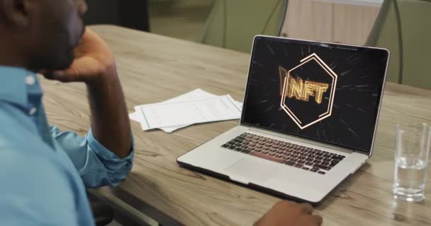 アフリカ系アメリカ人の男性がノートパソコンで作業している映像を画面上で ビジネス デジタルリソース テクノロジーの概念をデジタルで生成したビデオを扱う — ストック動画