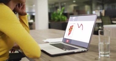 Çift ırklı iş kadını veri işleme ile video görüşmesi için dizüstü bilgisayar kullanıyor. ticari iletişim teknolojisi ve dijital kompozit video.