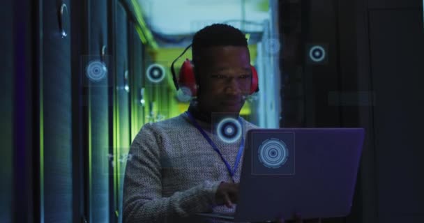 サーバールームで働くアフリカ系アメリカ人の男の上に円を処理するアニメーション ネットワーク プログラミング コンピュータ テクノロジーの概念がデジタルで生成され — ストック動画