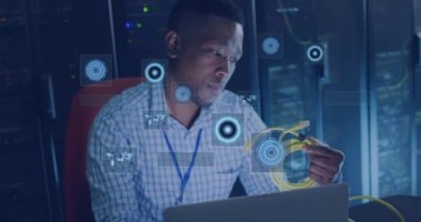 Sunucu odasında çalışan Afro-Amerikan bir adamın üzerinde yüzen çember işleme animasyonları. ağ, programlama, bilgisayarlar ve teknoloji konsepti dijital olarak oluşturulmuş video.