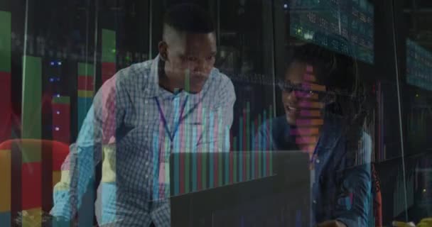 サーバールームで働くアフリカ系アメリカ人男性と女性に関するグラフのアニメーション ネットワーク プログラミング コンピュータ テクノロジーの概念がデジタルで生成され — ストック動画