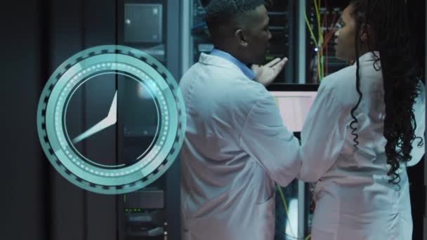 サーバールームで働くアフリカ系アメリカ人男性と女性の上を移動する時計のアニメーション ネットワーク プログラミング コンピュータ テクノロジーの概念がデジタルで生成され — ストック動画