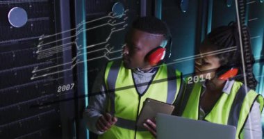 Sunucu odasında çalışan Afro-Amerikan erkek ve kadın üzerindeki çizgi ve numaraların animasyonu. ağ, programlama, bilgisayarlar ve teknoloji konsepti dijital olarak oluşturulmuş video.