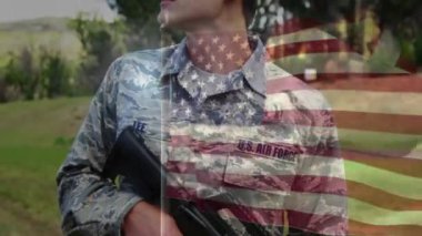 Beyaz erkek hava kuvvetleri askerinin elinde silah salladığı Amerikan bayrağının animasyonu. Vatanseverlik, bağımsızlık ve kutlama konsepti dijital olarak oluşturulmuş video.