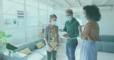 Animation of spinning human brain over businesswomen wearing face masks. global networks, business and connections during covid 19 pandemic concept digitally generated video.