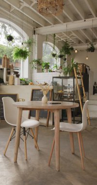 Kahve makinesinin üzerinde masaları ve sandalyeleri olan boş kafenin dikey görüntüsü. global işletme ve kahveci kafe.