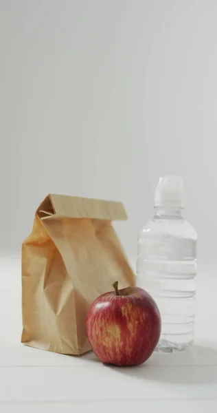 Imagem Vertical Almoço Embalado Saco Papel Com Maçã Água Sobre — Fotografia de Stock