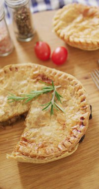 Eksik bir dilim ve biberiyeli, masada domatesli fırınlanmış baharatlı turtaların dikey görüntüsü. ev yapımı yemek, diyet ve beslenme.