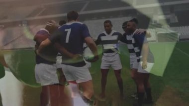Rugby oyuncularının ön planda ragbi mücadelesiyle stadyumdaki sahada bir araya toplanması.
