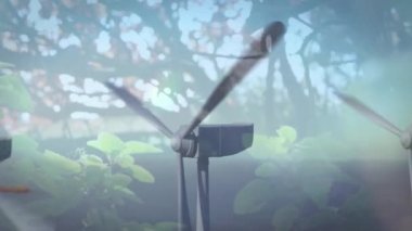 Ön planda ağaçlarla rüzgar türbinlerini döndürmenin animasyonu