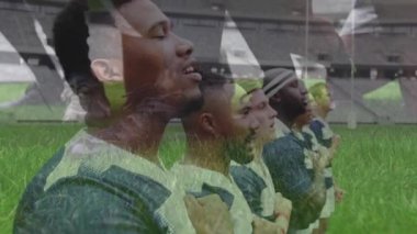Stadyumda oynanan maçtan önce milli marşı söyleyen rugby oyuncularının animasyonu. Ön planda yakın plan bir ragbi topu kargaşaya atıldı.