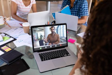 İş adamı, kadın meslektaşına ofiste video konferansı yoluyla iş stratejileri özetliyor. değiştirilmemiş, çevrimiçi, kablosuz teknoloji, tartışma, internet, iş, takım çalışması.
