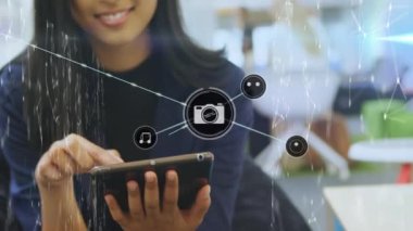 Tablet kullanan iki ırklı iş kadınının üzerindeki simgelerle bağlantı ağının animasyonu. Sosyal medya ve iletişim arayüzü kavramı dijital olarak oluşturulmuş video.