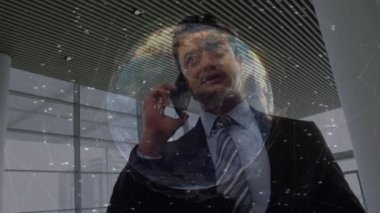 Animasyon bağlantıları ve akıllı telefon kullanarak çift ırklı iş adamının üzerine dünya. küresel iş, bağlantılar ve veri işleme kavramı dijital olarak oluşturulmuş video.