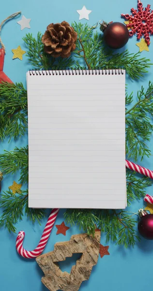 Mavi Arka Planda Noel Süslemeleriyle Çevrili Bir Defterin Dikey Görüntüsü — Stok fotoğraf