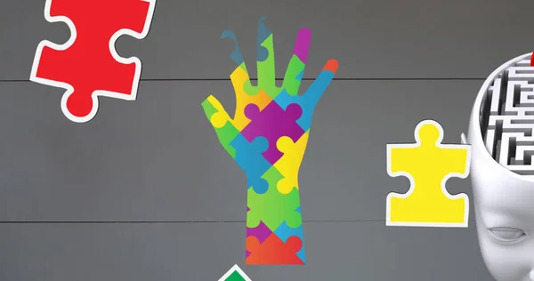 Image of autism awareness month colourful puzzle pieces forming hand and brain with maze. autism, learning difficulties, support and awareness concept digitally generated image.