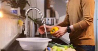 Mutfakta sebze yıkayan beyaz bir adamın orta kesiminde hareket eden ışığın animasyonu. Günlük hayat, ev kavramında dijital olarak oluşturulan video ile zaman geçirmek..