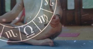 Kafkasyalı adamın yoga yapması üzerine yıldız falı zodyak çarkı animasyonu. Yıldız işaretleri, yıldız falı ve yoga meditasyon konsepti dijital olarak oluşturulmuş video.