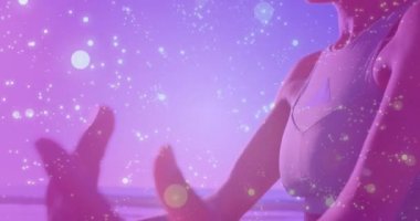 Sahilde yoga yapan beyaz bir kadının orta kesiminde ışıkların ve bağlantıların canlandırılması. Etkin yaşam tarzı, spor, rahatlama ve deniz konsepti dijital olarak oluşturulmuş video.