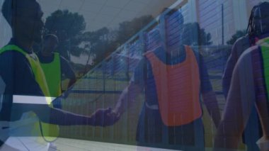 Çeşitli erkek futbolcuların spor sahasında el çırpması üzerine sunucuların animasyonu. spor, rekabet ve teknoloji konsepti dijital olarak oluşturulmuş video.