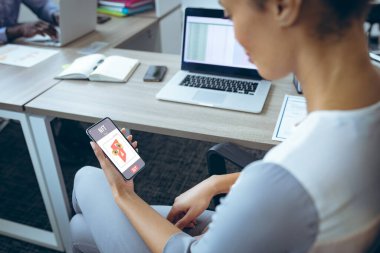 Ofiste otururken akıllı telefondan çift ırklı iş kadını arıyor. değiştirilmemiş, ödenemeyen jetonlar, kablosuz teknoloji, engelleme zinciri, finans, şifreleme, ticaret, araştırma.