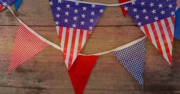 American flag design over decorative bunting flags on wooden surface with copy space. american independence and patriotism concept