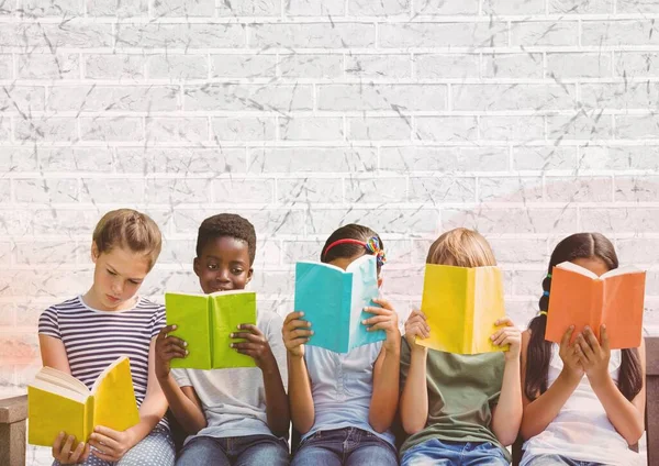 Group of diverse students reading books against grey brick wall background with copy space. school and education concept