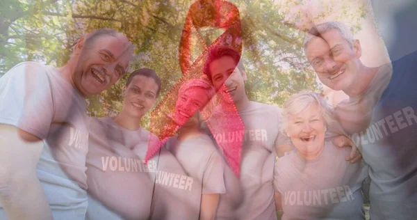许多快乐的高加索志愿者的肖像映衬在树上和红色的意识带上 国际慈善日 医疗保健 认识和庆祝 — 图库照片
