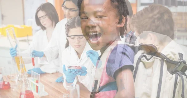 African american schoolboy with open mouth and multiracial students doing experiment in laboratory. Multiple image, education, international youth day, celebration, cultural, legal issues awareness.