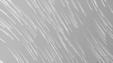 Gri arka plana düşen beyaz çizgilerin animasyonu. renk, hareket ve enerji, soyut arkaplan kavramı dijital olarak oluşturulmuş video.