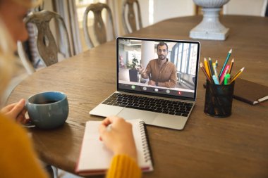 İnternette beyaz kadın meslektaşıyla buluşup içki içen iki yüzlü iş adamı. Değiştirilmemiş iş, kablosuz teknoloji, çalışma, içki, takım çalışması ve ofis konsepti.