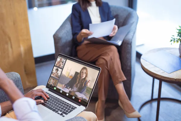 Çok ırklı iş arkadaşlarıyla çevrimiçi toplantı sırasında Afrikalı Amerikalı iş adamı. Değiştirilmemiş iş, kablosuz teknoloji, toplantı, çalışma, takım çalışması ve ofis konsepti.